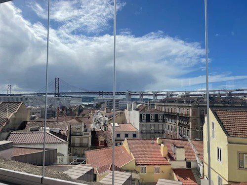 a view of Lisbon and the 25 April bridge from Lapa through glass