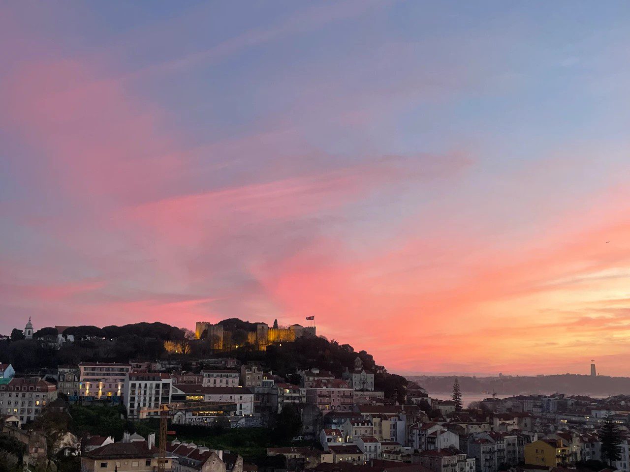 view of a sunset facing the river and Castelo do Sao Jorge from Graça in Lisbon Portugal